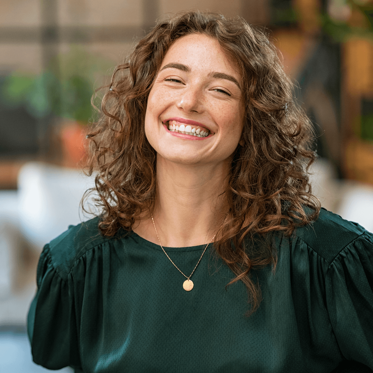 Emily R, with her curly hair, beams with joy, highlighting her excellent experience with Moon Investments.