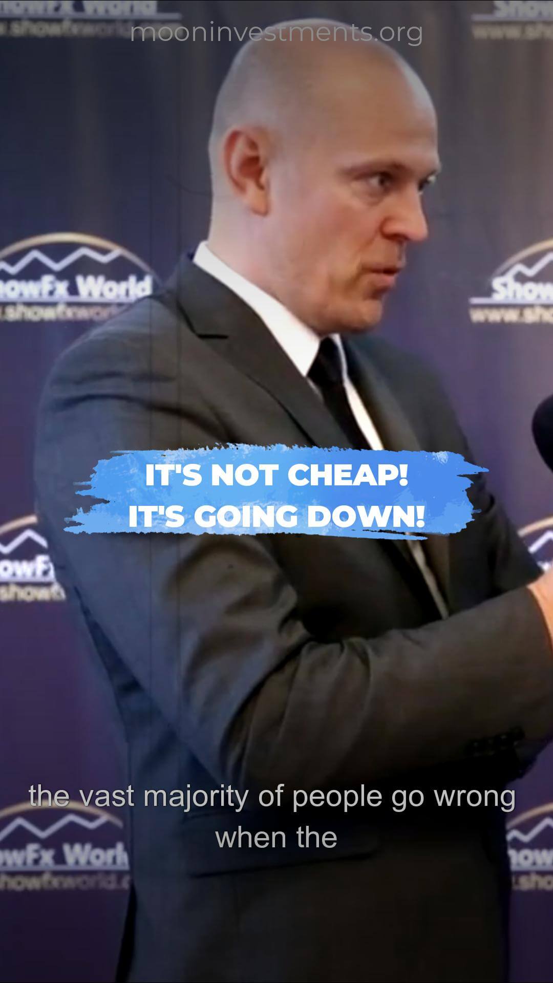 Bald man in a suit, promotional text overlayed, stating "It's not cheap! It's going down!".